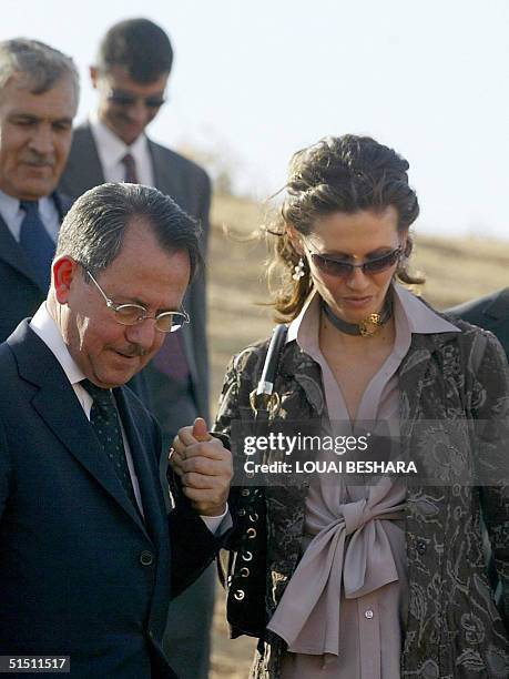 Syria's First Lady Asma al-Assad holds her father Fawaz al-Akhras' hand as she tours the historic Syrian city of Ebla, 300 kms north of Damascus, 20...