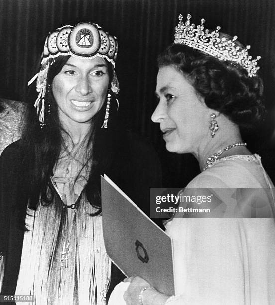 Queen Elizabeth walks past American singer-songwriter Buffy Sainte-Marie after the artist performed with three other acts for the Queen and Prince...