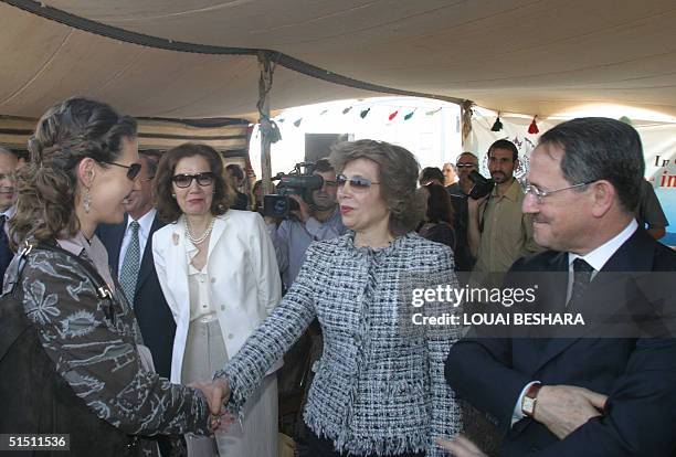 Syria's First Lady Asma al-Assad shakes hands with her mother as her father, Fawaz al-Akhras , looks on at a ceremony in the historic Syrian city of...
