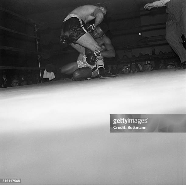 Ray Patterson, brother of Floyd Patterson, holds legs of Chuck Wepner as he goes down for a count of eight in second round of a scheduled six-round...