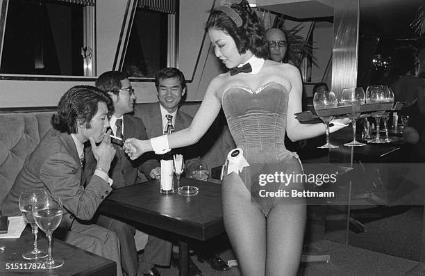 Rie Taga, one of the new Japanese bunnies in the newly opened Tokyo Playboy Club here serves drinks and lights cigarettes for customers at a special...