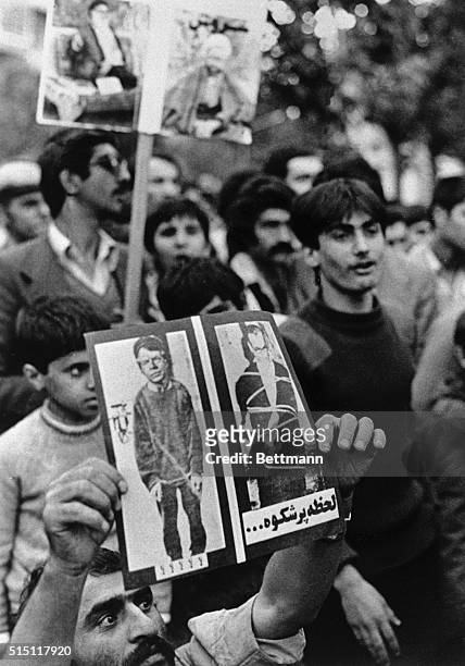 Demonstrators, supporting the seizure of the U.S. Embassy and dozens of American hostages within, show poster depicting President Jimmy Carter and...