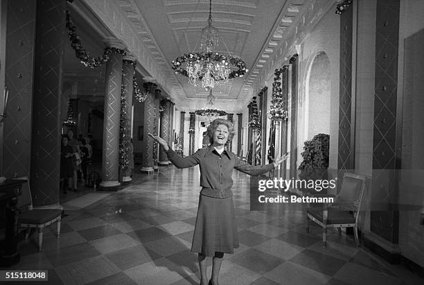 Mrs. Pat Nixon serves as the tour guide during a press preview of the Christmas decorations in the White House 12/11. Here she stands in the Cross...