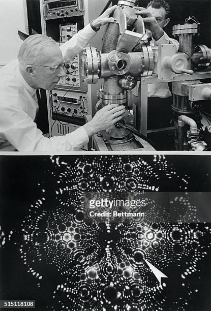 Professor Erwin Mueller of the Pennsylvania State University peers into the viewing port of his newly developed atom-probe field ion microscope ....