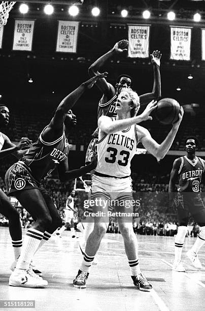 Celtics' Larry Bird keeps his eye on the basket as he is double-teamed by Detroit Piston's Terry Tyler and Gregory Kelser during third quarter action...