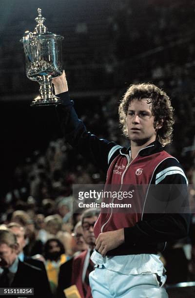 John McEnroe holds his trophy above his head after defeating Vitas Gerulaitis in the finals of the U.S. Open Men's Singles Championship here...