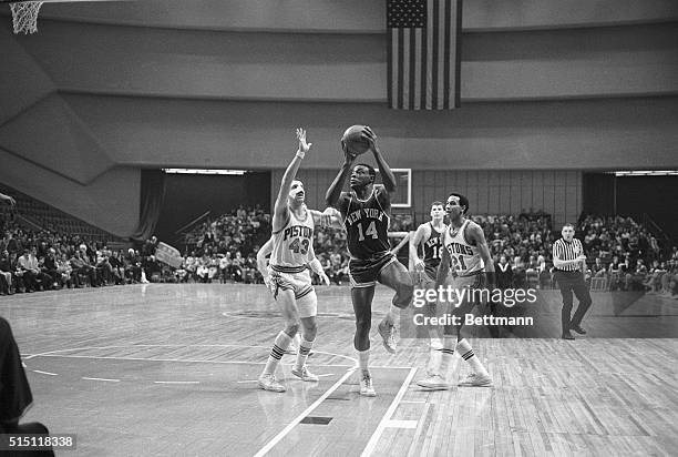 Guarded by Pistons Terry Dischinger and Dave Bing , Knicks Cazzie Russell shoots during the 1st half of the Detroit-New York game at Detroit's Cobo...