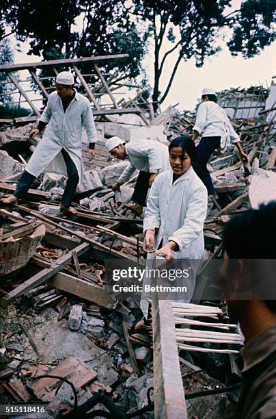 Hanoi, North Vietnam: North Vietnamese doctors and nurses carry a box of medical supplies out of the destroyed Bac-Mai hospital bombed by U.S. B52...