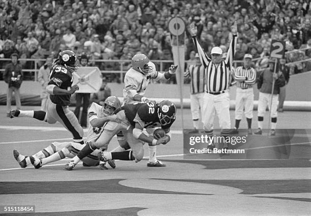 Pittsburgh Steelers' Franco Harris carries Cincinnati Bengals' Tom Casanova over the goal line during the fourth quarter as Steelers' John Fuqua and...