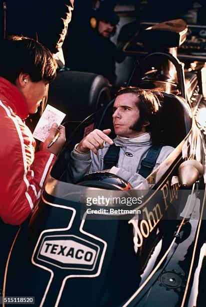 Brands Hatch, England: Autoracer Emerson Fittipaldi of Brazil with his car prior to the pactice run of the Brands Hatch auto race.