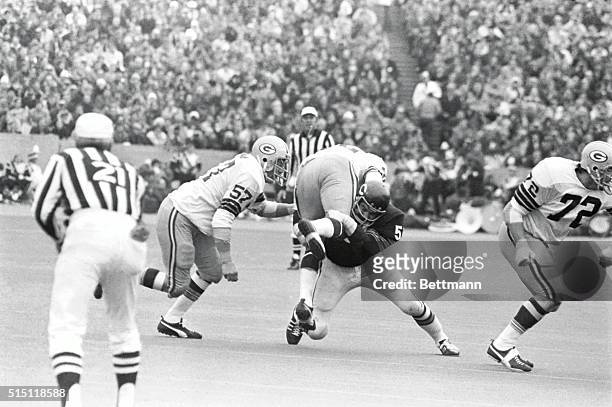 Bears linebacker Dick Butkus lifts Green Bay Packers running back John Brockington off the turf as he makes this crushing tackle during the second...