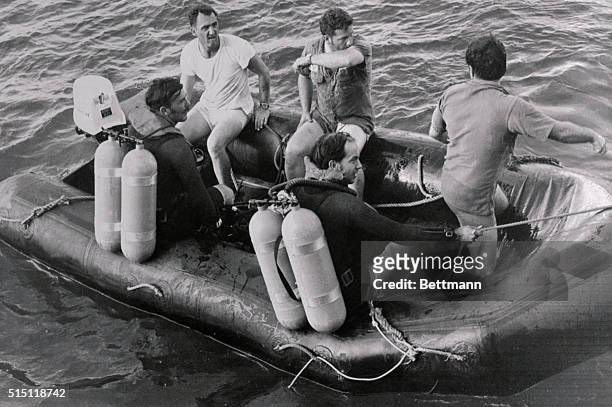 Navy divers take a break during the 12th day of searching for the bodies of baseball great Roberto Clemente and three others killed in a plane crash...