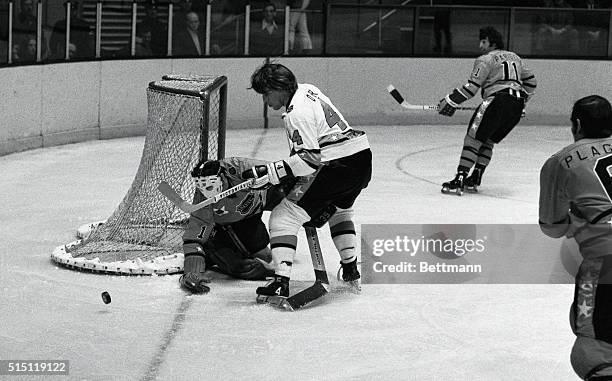 West Division All-Stars' goalie Tony Esposito deflects puck off stick of East Division's Bobby Orr during first period of NHL All-Star game here,...