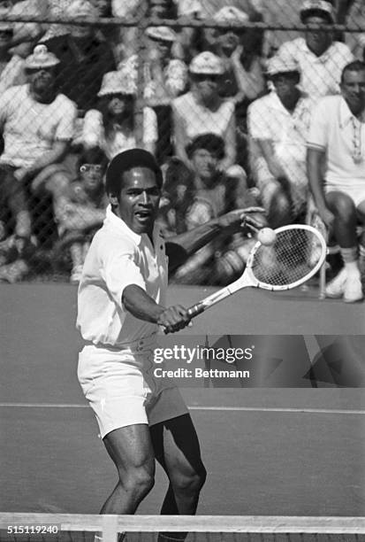 Simpson, of the Buffalo Bills, has his tongue out as he returns a shot from Jack Ham, of the Pittsburgh Steelers, during a "Superstars" tennis match....