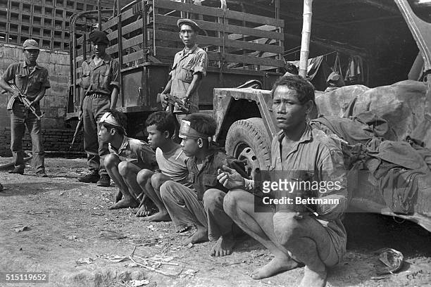With hands tied behind their backs, Khmer Rouge captives are guarded, August 26th, by Government soldiers armed with Russian-made rifles at Angkor,...
