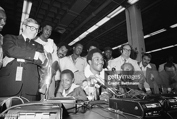 Uniondale, NY: George Foreman, and his son, Darrin, at his side, talks to reporters after his fifth round TKO of Joe Frazier.