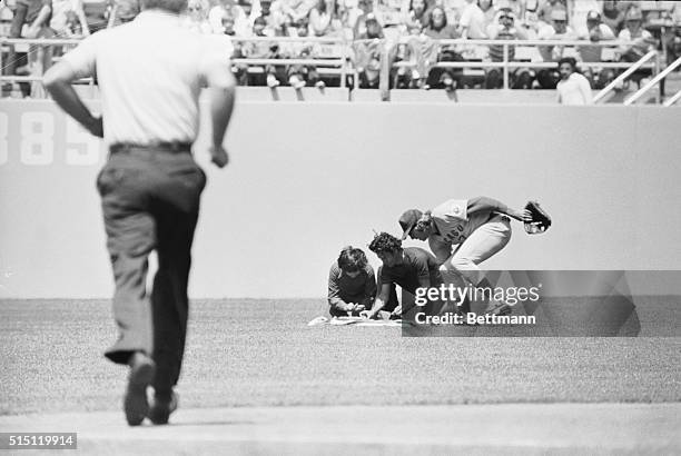 April 25, 1976-Los Angeles, California: On a dead run from centerfield, Chicago Cubs Rick Monday reaches to rescue an American flag as two men...