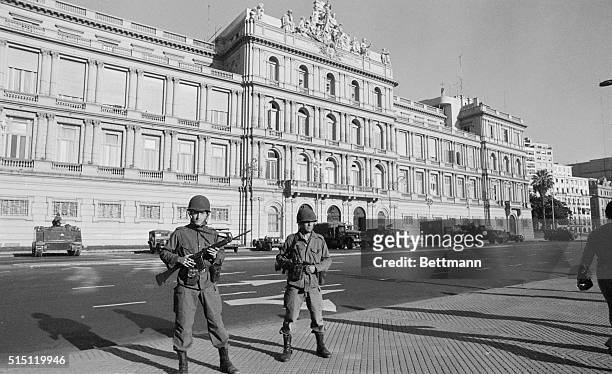 Buenos Aires, Argentina: Soldiers in full war gear stand guard in front of Casa Rosada March 24 after a military Junta, composed of the three Armed...