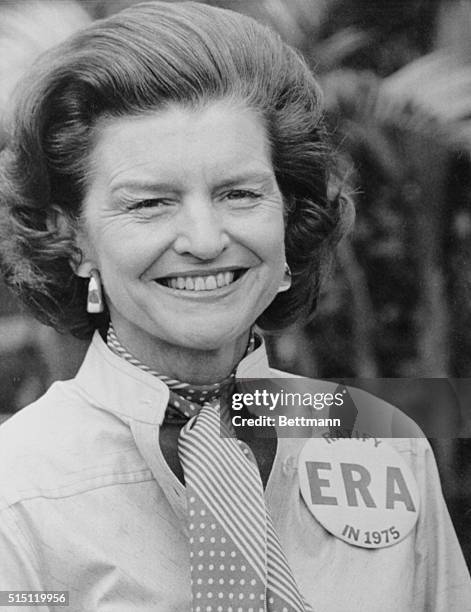 Lauderhill, Florida: First Lady Betty Ford shows off the "ERA" button given her while her husband plays golf, February 26. Mrs. Ford has expressed...