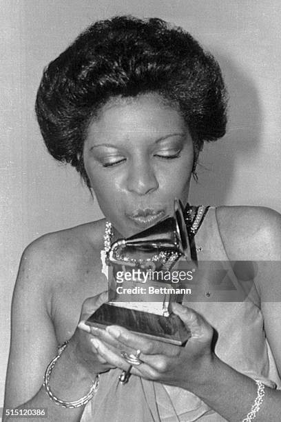 Natalie Cole kisses her trophy after winning her award for "Best Newcomer of the Year" at the 18th Annual Grammy Presentations, February 28th.