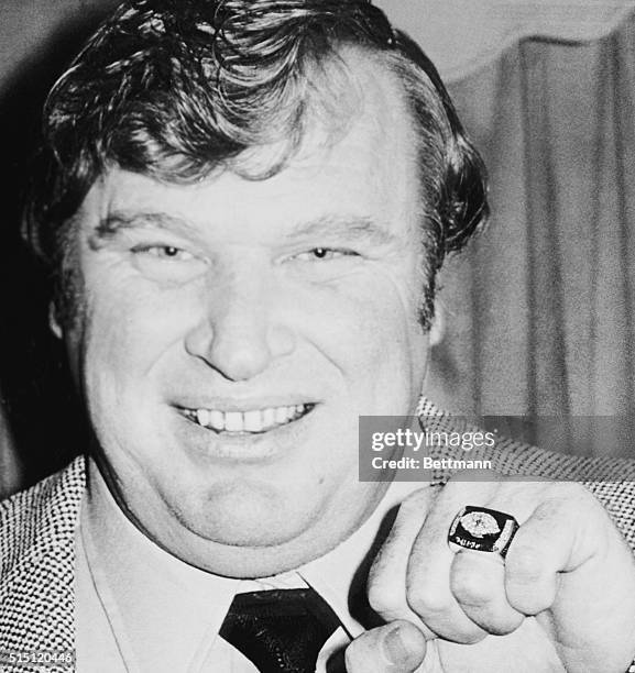 Oakland, Calif.: Oakland Raiders Head coach John Madden models the glittering super prize of professional football, the Super Bowl XI Championship...