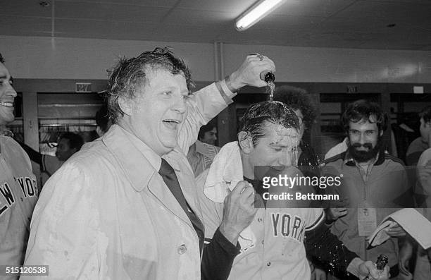 New York Yankees owner George Steinbrenner pours champagne over the head of his manager, Billy Martin, in the dressing room after the Yankees beat...