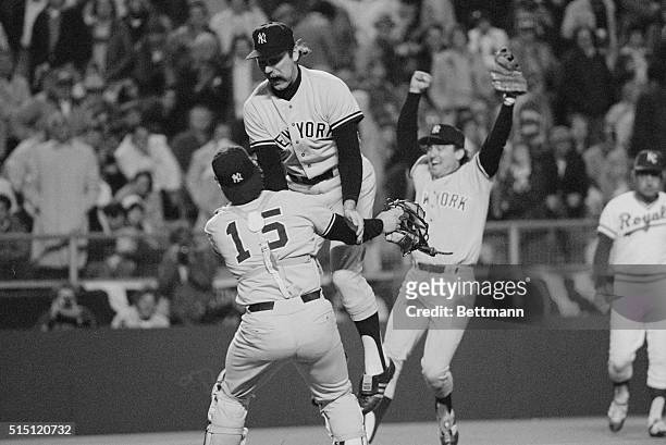 With Yankee 3rd baseman Graig Nettles running in to join the celebration, pitcher Sparky Lyle leaps into the arms of catcher Thurman Munson after the...