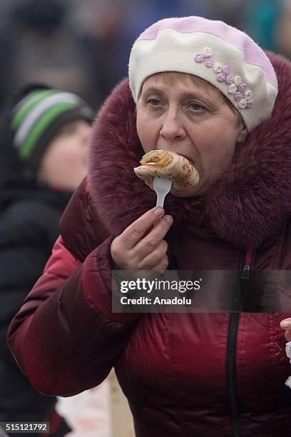 Russian woman eats pancake during the Maslenitsa festival in Moscow, Russia on March 12, 2016. Maslenitsa is a sun-festival and a celebration of the...