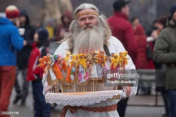 Man wearing traditional costume sells baby dolls during the Maslenitsa festival in Moscow, Russia on March 12, 2016. Maslenitsa is a sun-festival and...