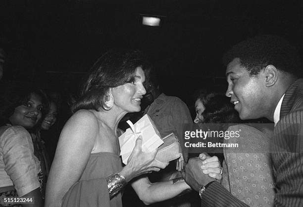 World Heavyweight Boxing Champ Muhammad Ali shakes hands with Jacqueline Onassis as they meet at pre-game bash, here 8/26, of the annual Robert F....
