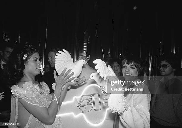 Model Bianca Jagger and singer Liza Minnelli holding white doves at the popular nightclub Studio 54.