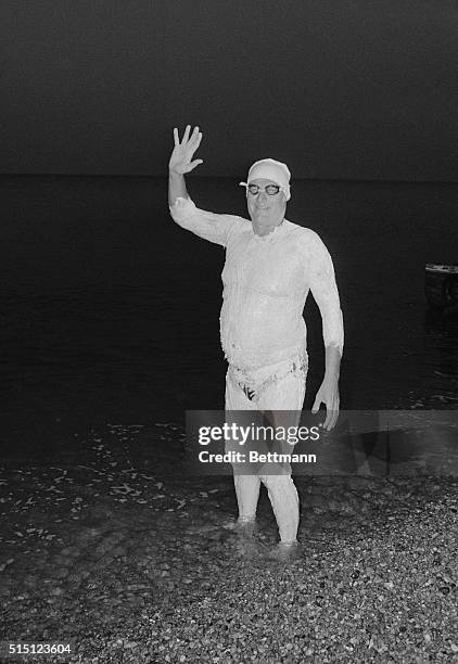 Dover, England: Dr. James Counsilman the famed swimming coach of Indiana University, entering the water with a wave at Shakespeare Bay early this...