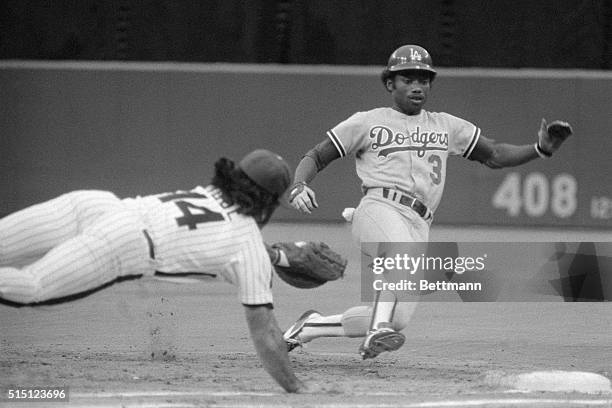 Phillies' Pete Rose, left, dives back to first base to unsuccessfully tag out Dodgers' Derrell Thomas who had rounded first base and had started to...