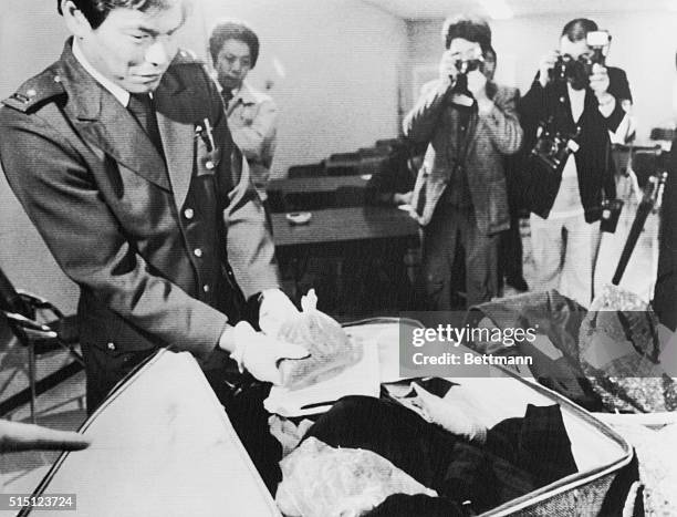 Customs officer inspects one of the plastic one of the plastic bags containing marijuana which hidden inside one of Paul McCartney's luggages after...