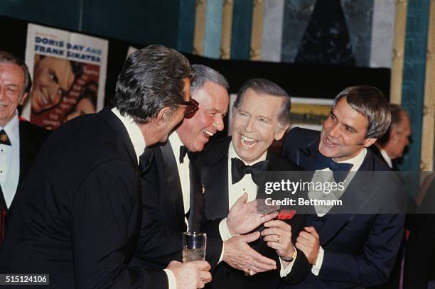 Frank Sinatra claps his hands as he is congratulated by Dean Martin, Milton Berle and Rich Little after Sinatra received the first "Pied Piper Award"...