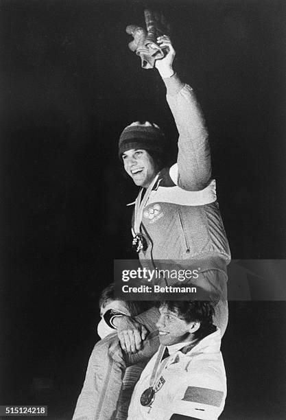 Eric Heiden, winner of a record five gold medals in Winter Olympic competition, is hoisted to the shoulders of his runners-up at medal presentation...