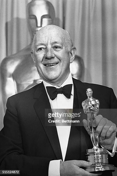 Hollywood: Sir Alec Guiness smiles happily after receiving the Motion Picture Academy's most unusual presentation for advancing the art of screen...