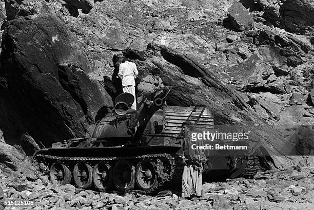 Afghan Moslem rebels pose around a destroyed Russian-made light tank in the Kama Valley here 40 kms west of the Pakistan border. The tank was...