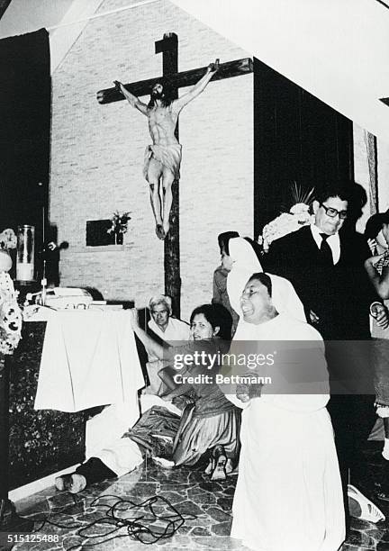 San Salvador, El Salvador: A nun kneels in prayer as the body of Archbishop Oscar A. Romero is attended shortly after he was assassinated by four...