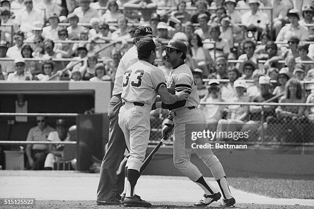 Bloomington, Minn.: New York Yankees' Reggie Jackson holds his bat and attempts to push his way past Yankees' coach Mike Ferraro to reach Minnesota...