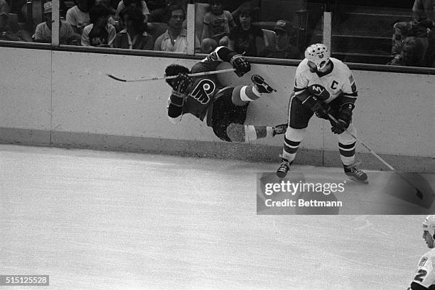 Uniondale, New York: Denis Potvin of the Islanders checks the Flyer's Reggie Leach to the ice in the first period of game six of the Stanley Cup...