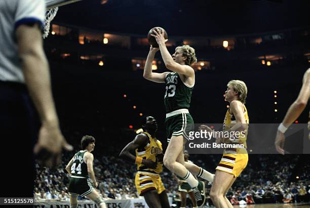 Larry Bird of the Boston Celtics in action goes up for a layup between Cavaliers Don Ford and Foots Walker.
