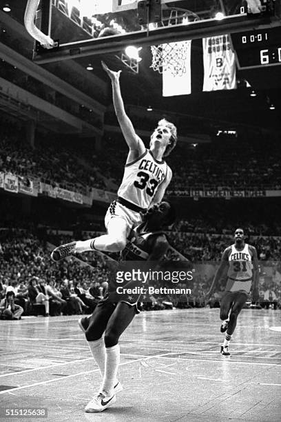Celtics' Larry Bird finds himself on the shoulders of Washington Bullets' Kevin Porter while going for a driving layup during 2nd quarter action of a...