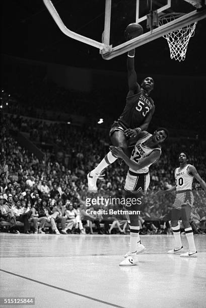 Los Angeles Lakers Earvin "Magic" Johnson grimaces as he is hit by Philadelphia 76ers 6-11 1/2 footer Darryl Dawkins as the 76ers take a lead in game...