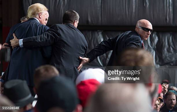 Secret Service swarms around Republican Presidential candidate Donald Trump after a bottle was thrown on stage at a Campaign Rally on March 12, 2016...