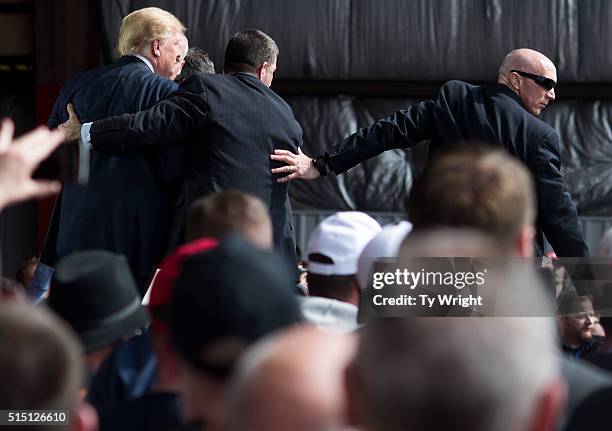 Secret Service swarms around Republican Presidential candidate Donald Trump after a bottle was thrown on stage at a Campaign Rally on March 12, 2016...