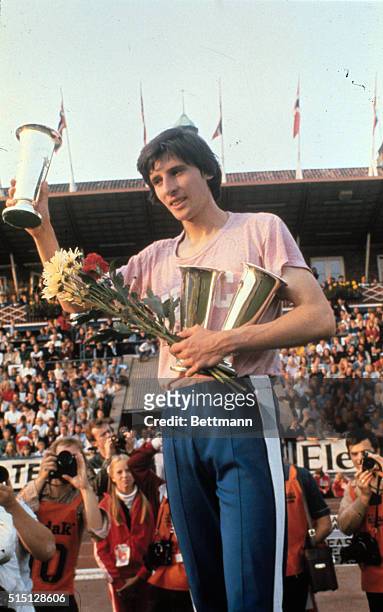 Holding a bouquet and raising his trophy, Britain's star runner, Sebastian Coe, celebrates his triumph in the 1,000 meters race at the 1980 Bislett...