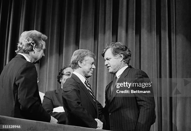 New York: Unity? President Jimmy Carter, , and Senator Edward Kennedy shake hands at the conclusion of the Democratic National Convention, August...