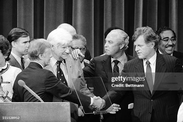New York: President Carter and Sen. Edward Kennedy finally shake hands as Democratic Convention chairman Thomas "Tip" O'Neill and carter campaign...