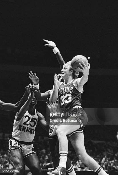 Boston Celtics' Larry Bird barrels past New York Knicks' Len Robinson as Bird puts the ball up with a hook shot to score for the Celtics during the...